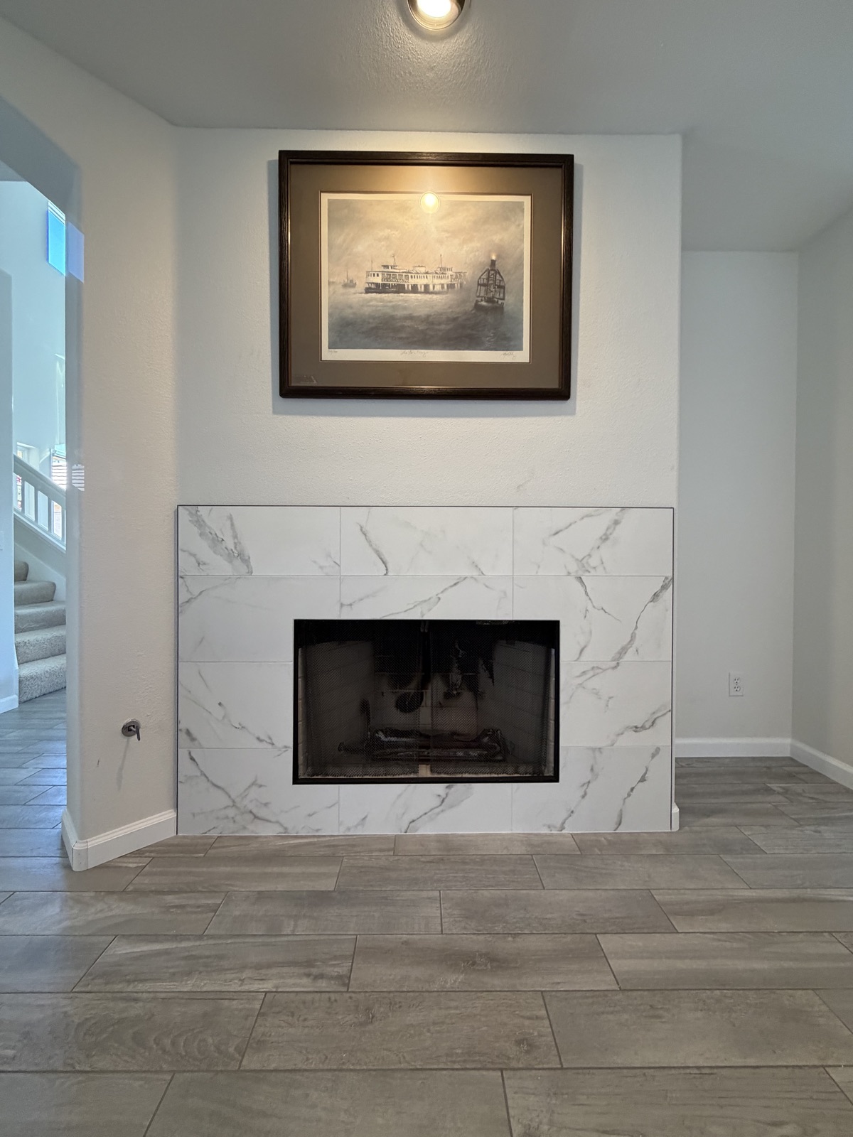 After: the same fireplace finished in marble-look tile