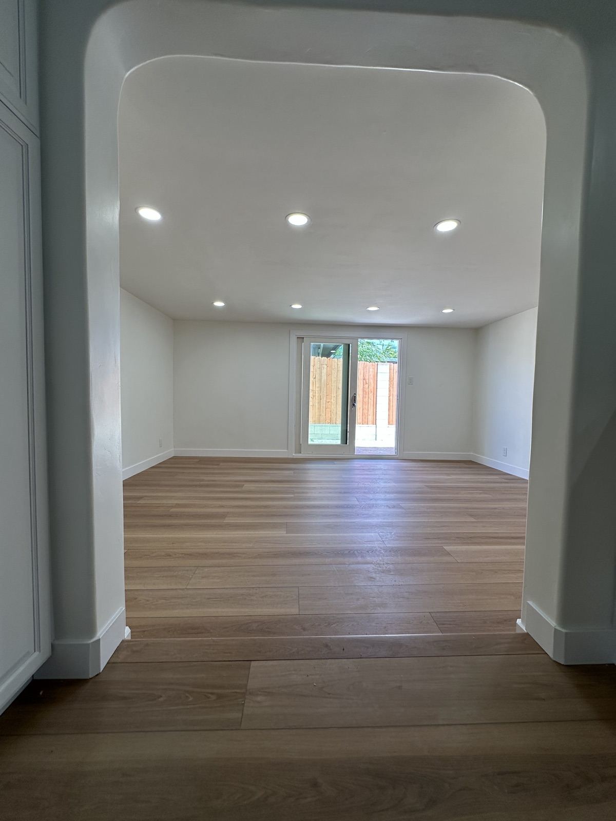 Arched living room opening with white oak flooring after a whole-home remodel in Oceanside