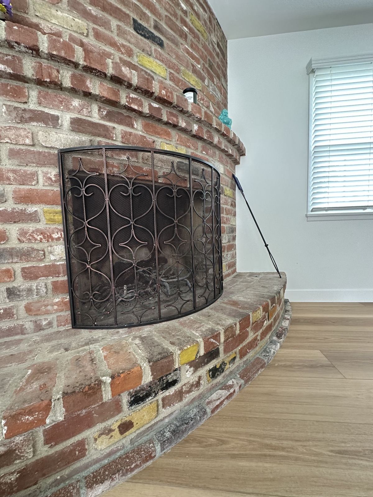 Restored brick fireplace beside new white oak floors in the Oceanside remodel