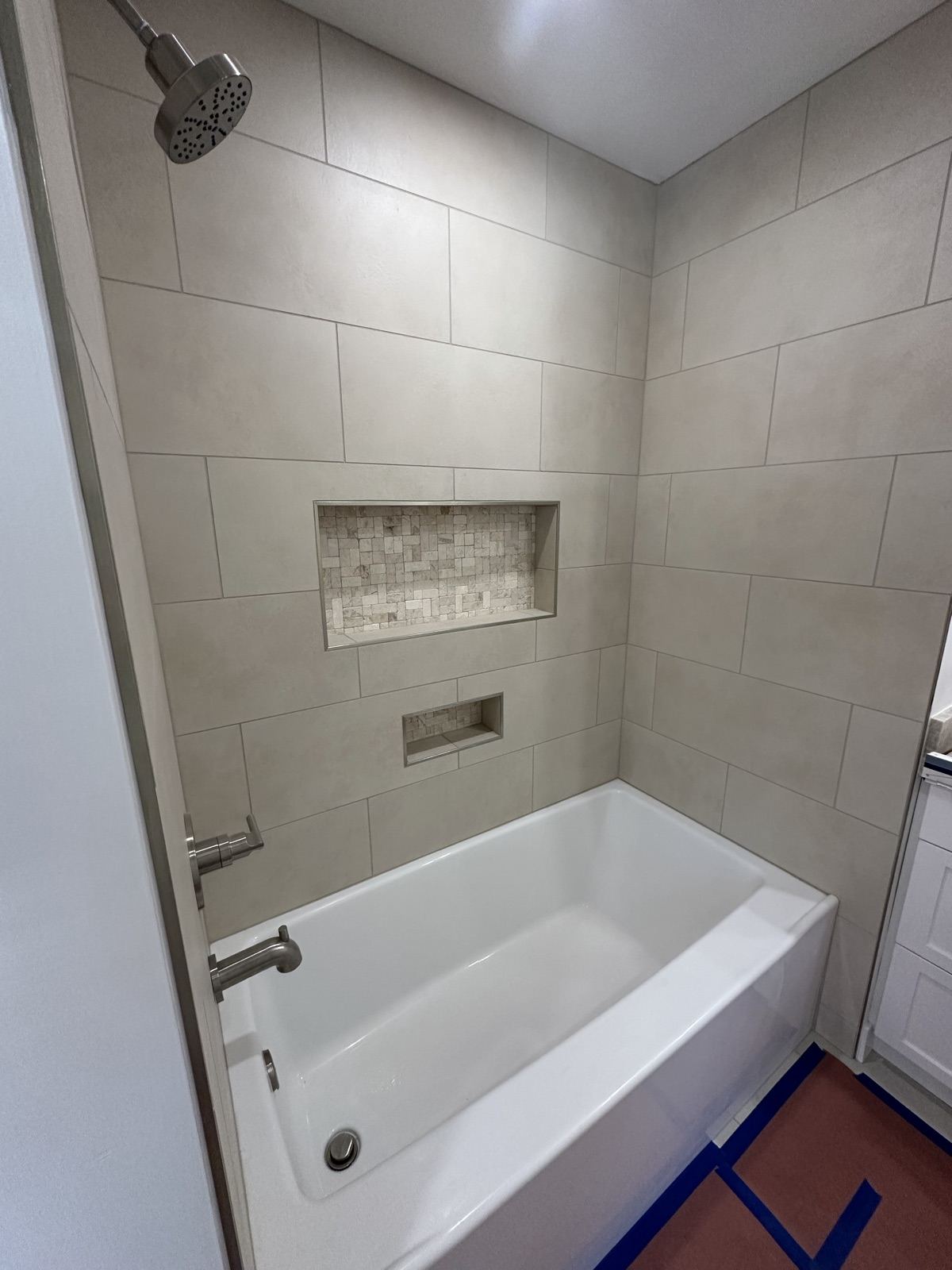 Rebuilt tub and shower with custom tile niche in the Oceanside whole-home remodel