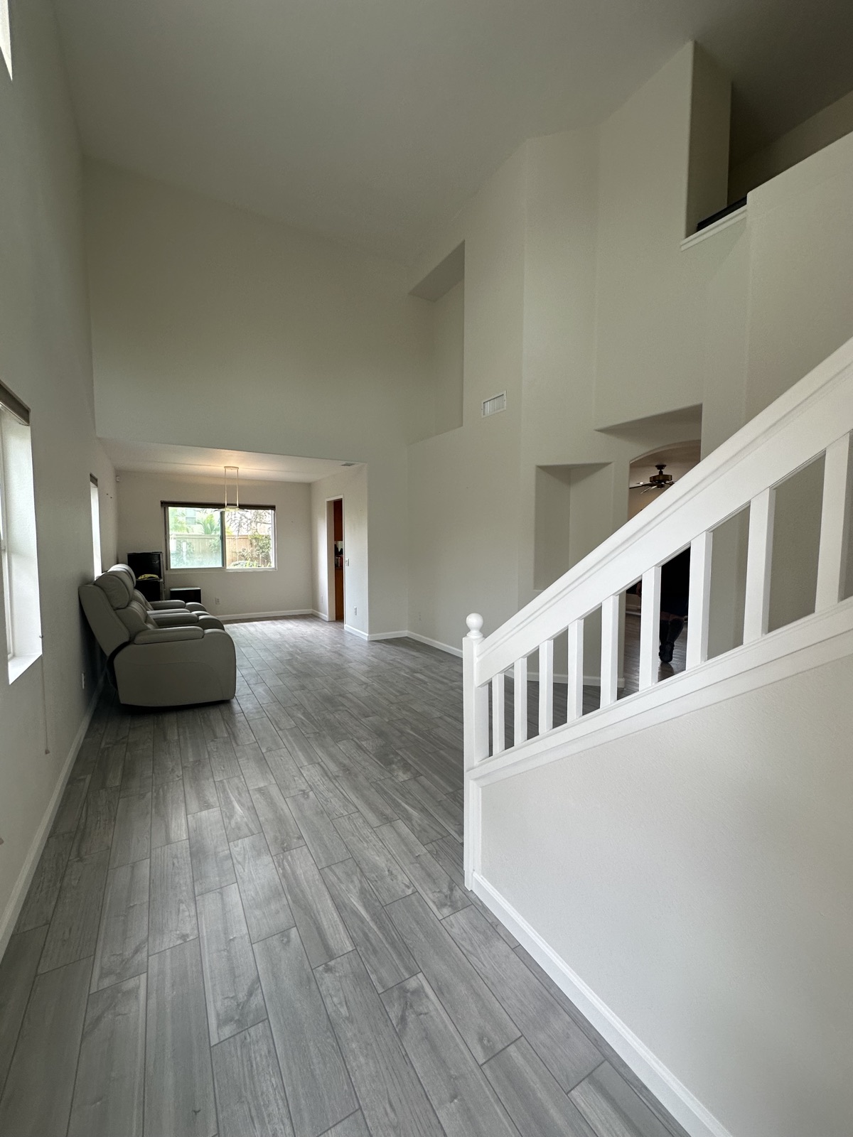 Living room with new plank flooring and refinished staircase in Poway